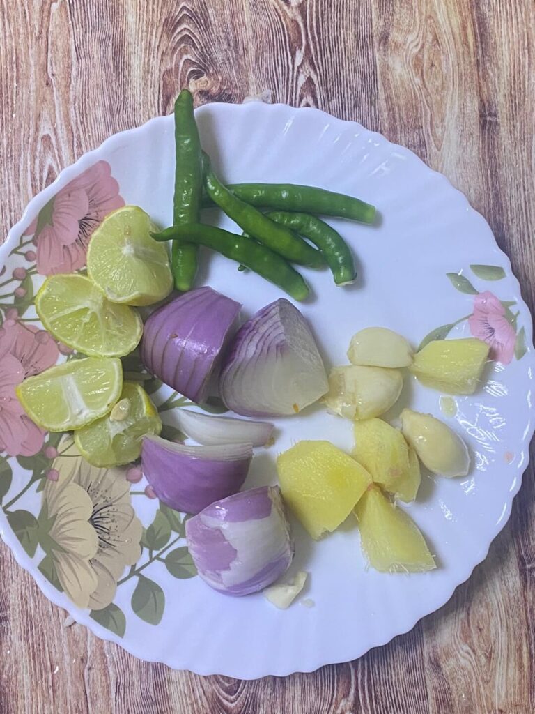 onions, ginger garlic greeen chillies and lemons in a plate